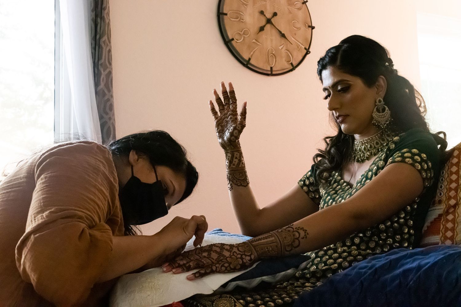Artist applies intricate henna design during traditional Indian wedding preparation.