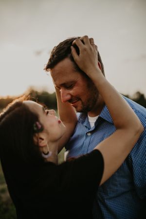 A couple shares a passionate moment together during a sunset photoshoot.