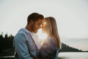 Romantic sunset photoshoot with lens flare and mountain scenery.