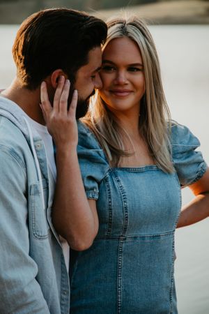 Intimate lakeside portrait session featuring denim outfits and natural lighting.