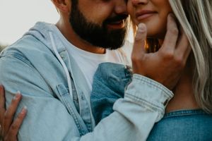 Close-up shot of couple in denim sharing intimate moment by the water.