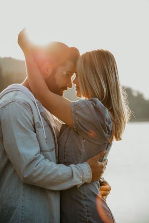 Romantic golden hour portrait with soft backlighting and lake views.