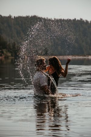 Splashing water creates dramatic effects as people play in a scenic lake.