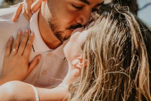 A romantic couple shares a tender moment in warm golden sunlight.