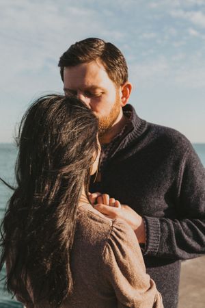 Intimate couple photography session at the beach with soft natural lighting.