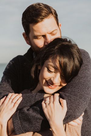 Close-up shots of a couple sharing tender moments in grey winter clothing.