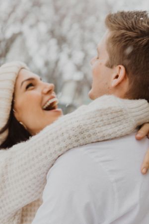 A couple wearing winter scarves laughs together in a series of candid shots.