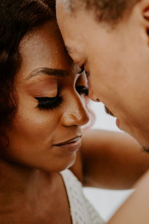 Sepia-toned intimate close-up of newlyweds sharing a tender moment.