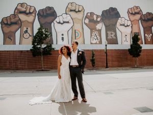 A wall mural featuring raised fists in different skin tones with text in between.