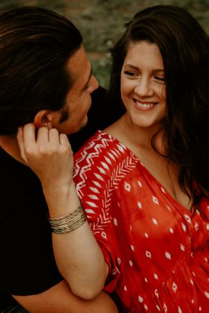 Romantic couple in casual attire sharing intimate moments outdoors.