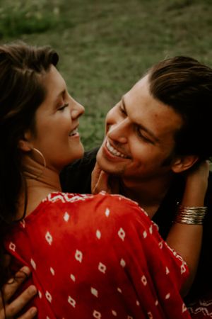 Couple laughing and embracing in warm sunset lighting.
