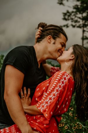 Romantic couple embracing in an outdoor setting with natural lighting.