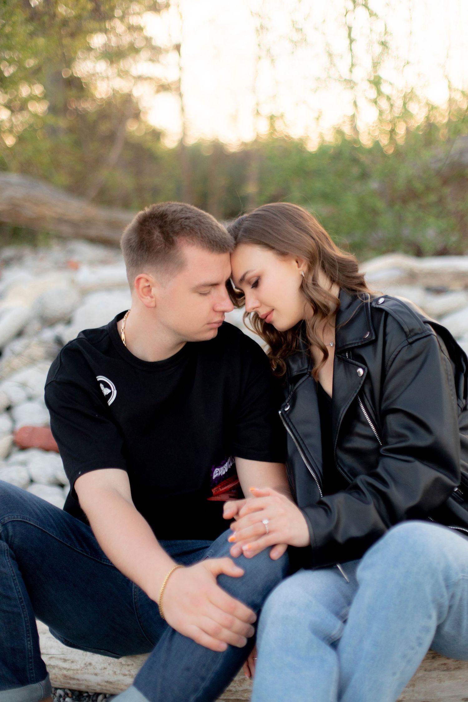 A couple shares an intimate moment while sitting together outdoors at sunset.
