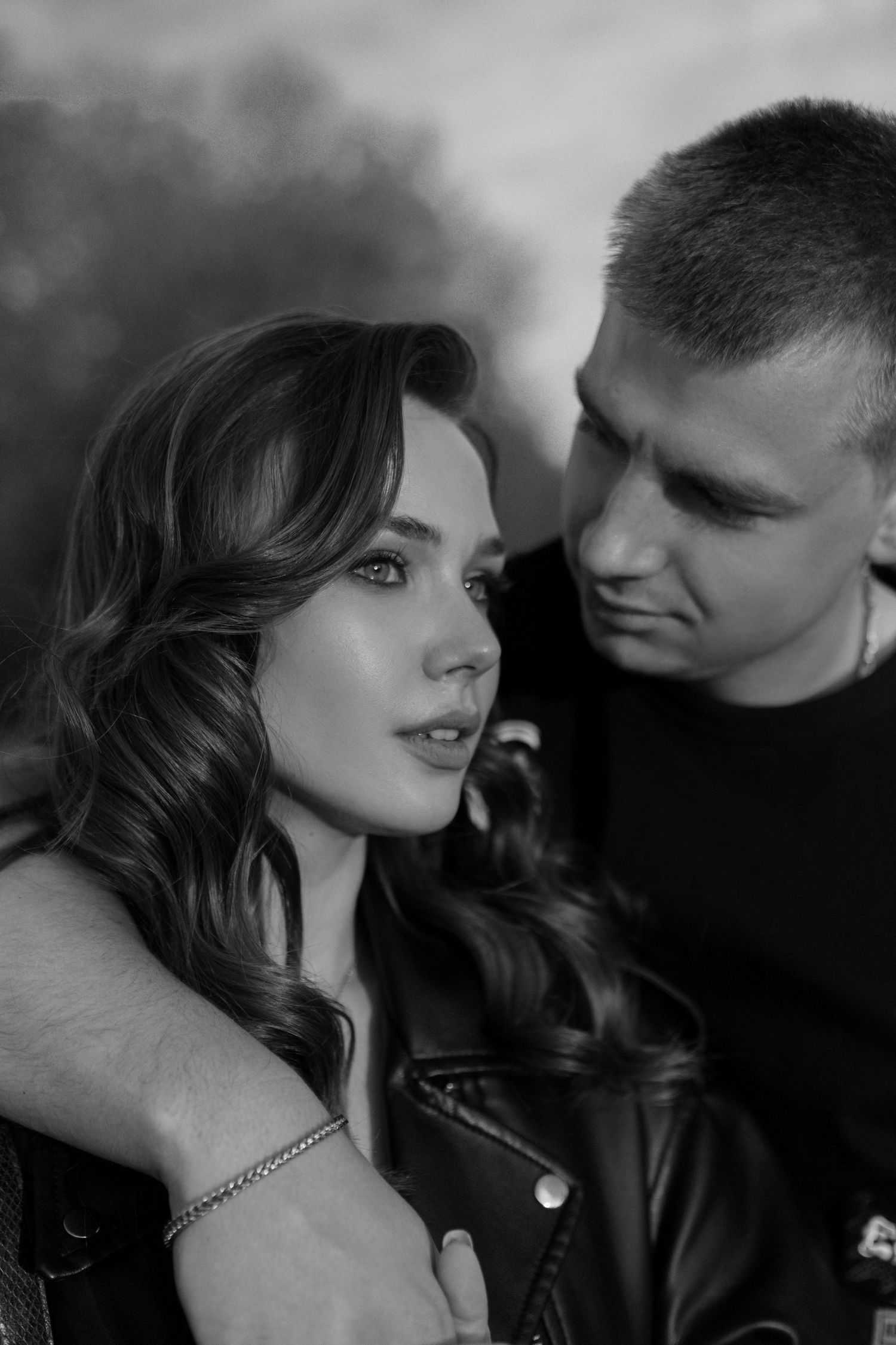 An artistic black and white portrait of a couple in leather jackets.