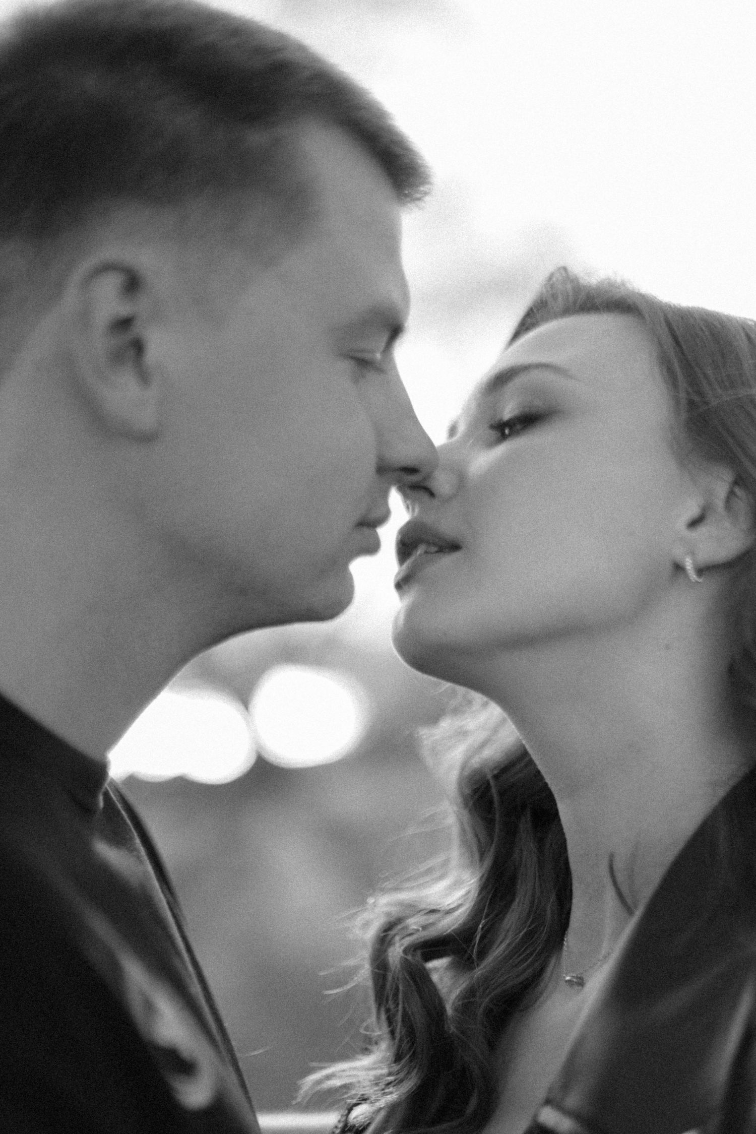 A romantic black and white portrait captures an intimate moment between a couple.