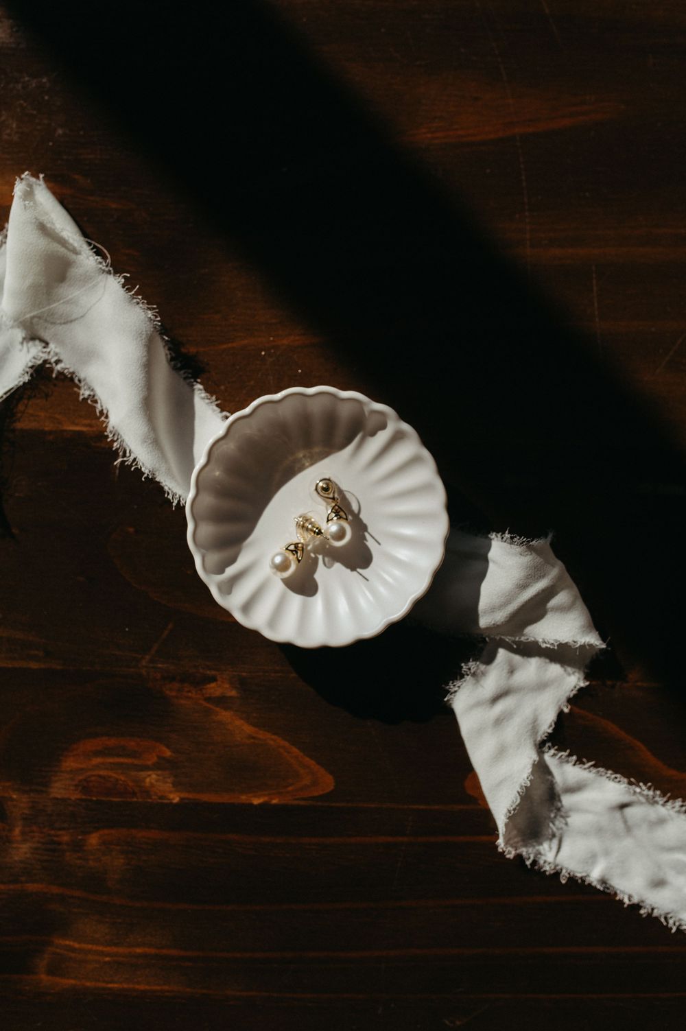 White porcelain dish with gold details displayed on dark wooden surface.
