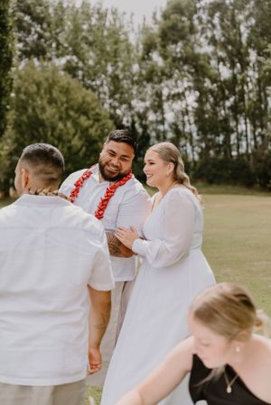 Wedding ceremony participants sharing a joyful moment during an outdoor service.