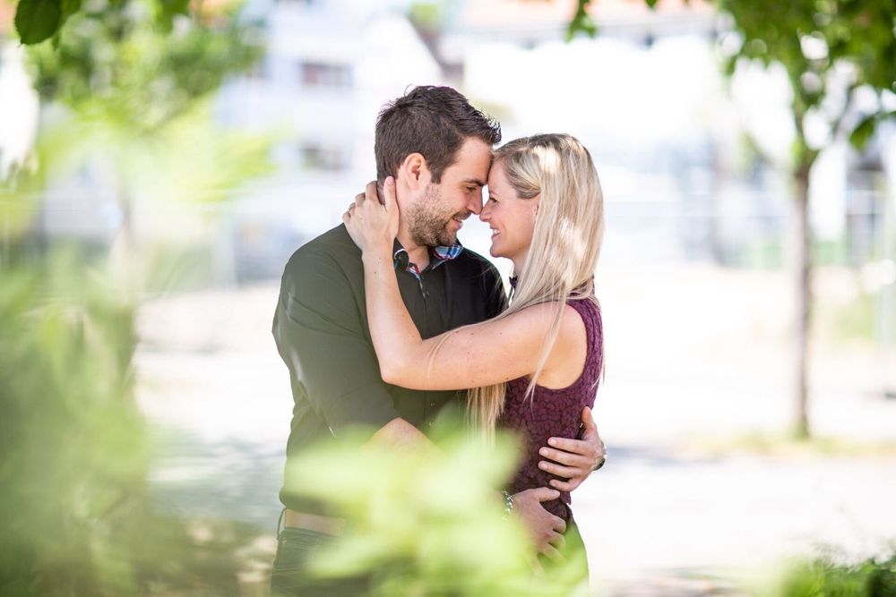 Lovebirds umarmen sich zärtlich, festgehalten von einem Fotografen in einem liebevollen Bild.