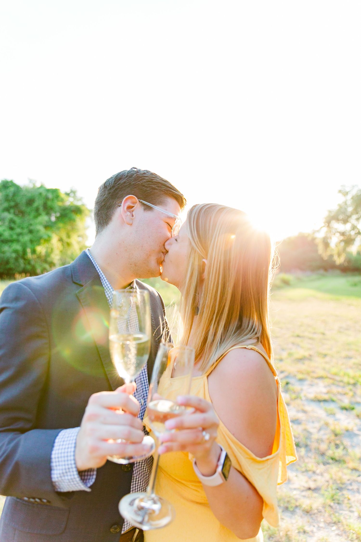 Couple sharing champagne during golden hour engagement photoshoot.