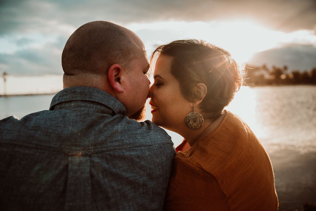 The sunset behind a couple touching noses