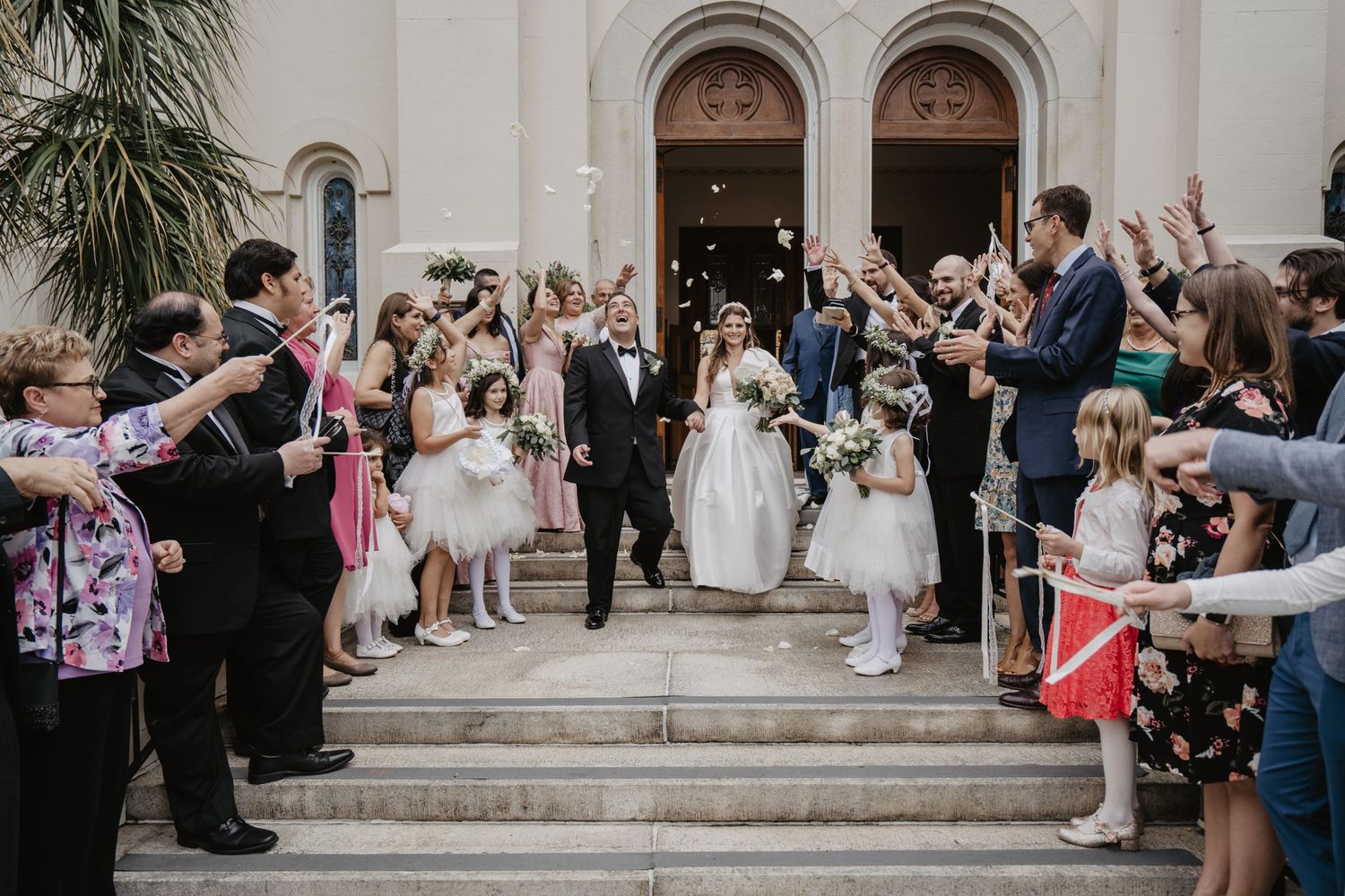 bride and groom leaving the reception with white rose petals