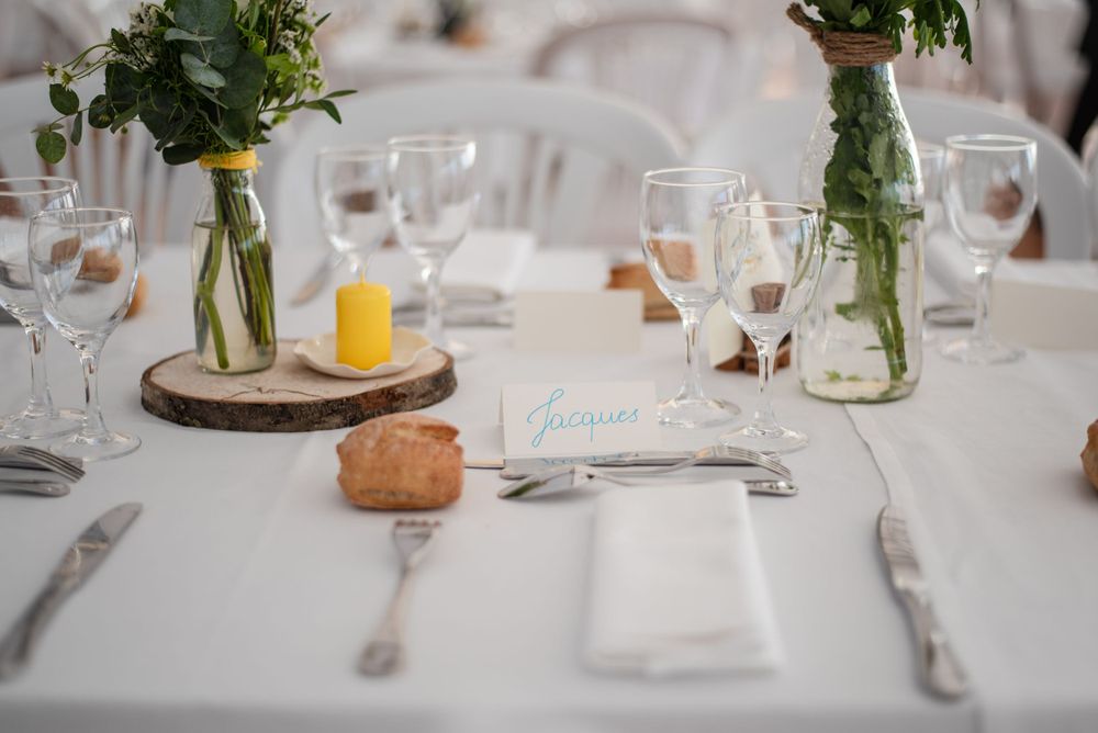 Elegant table settings with wine glasses and small floral centerpieces.