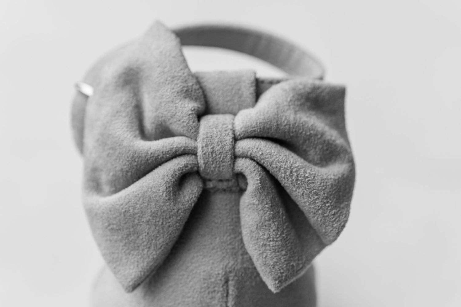 Gray fabric bow ties arranged in a row on a light background.