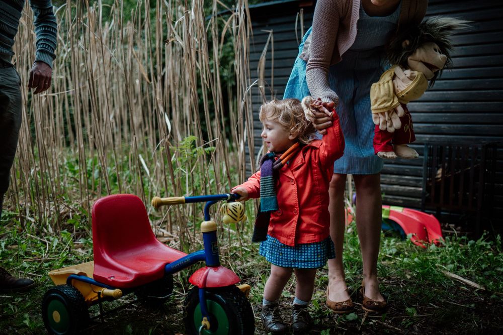 A playful swing set moment captured outdoors with natural vegetation in the background.