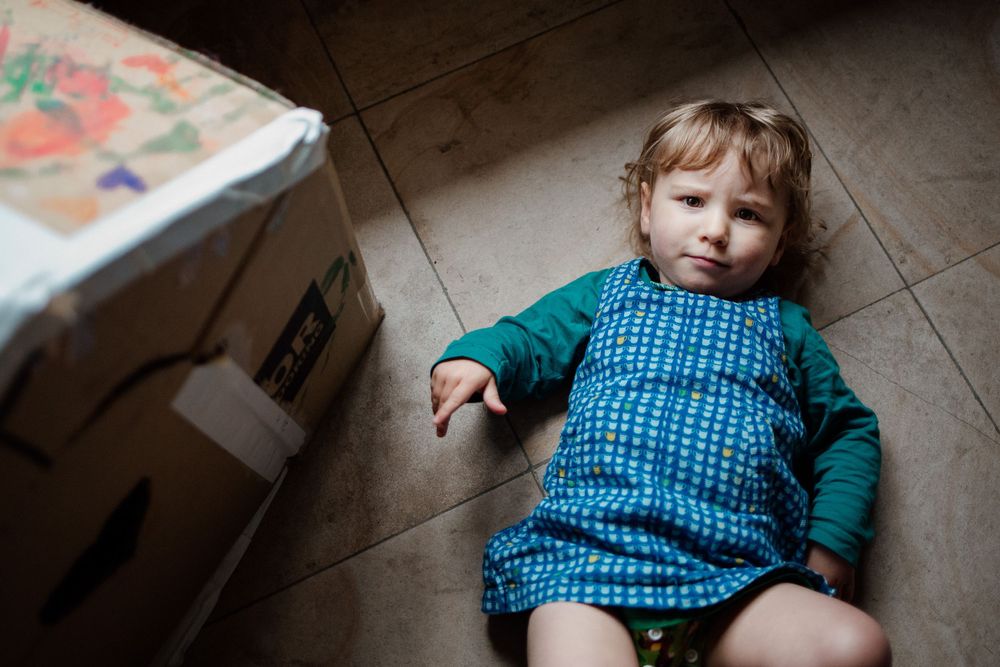 A low-angle view of someone wearing a blue checkered outfit on a wooden floor.