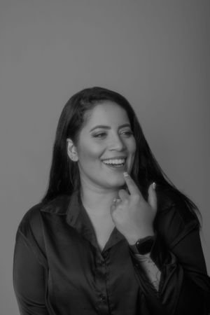 Black and white portrait showcasing joyful expression and long dark hair.