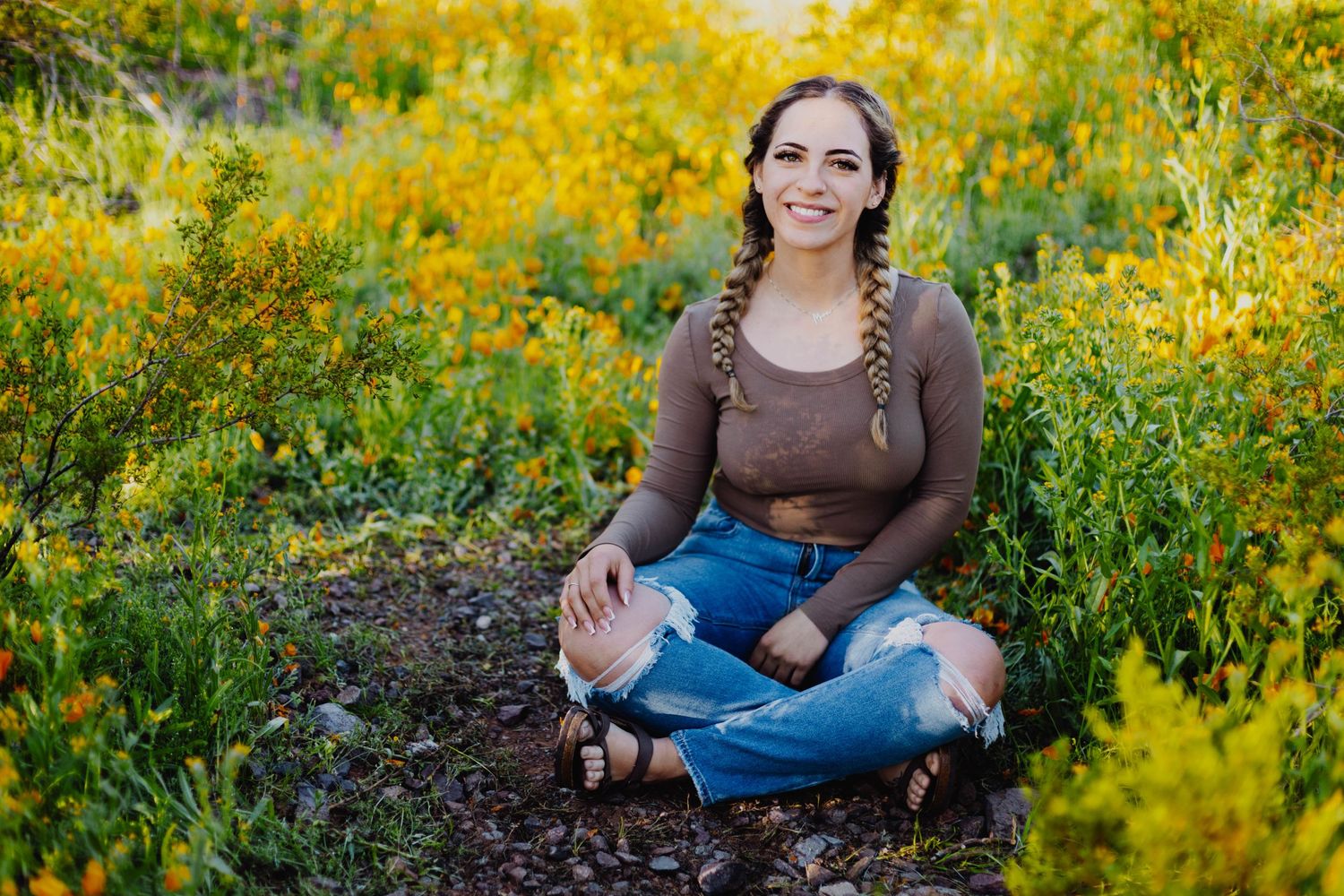 A casual portrait surrounded by bright yellow wildflowers in a natural garden setting.