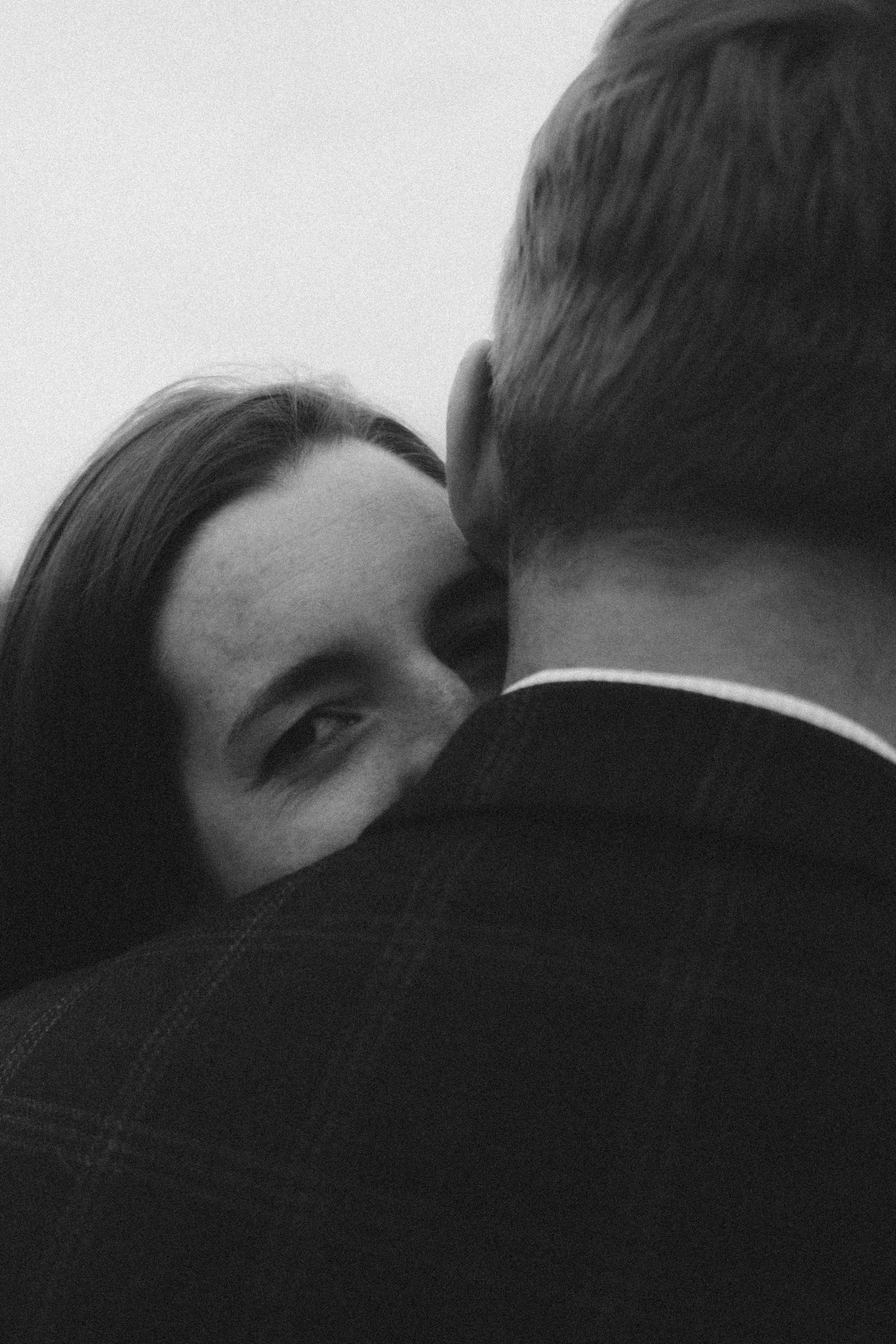 An intimate black and white photo of a couple in close embrace.