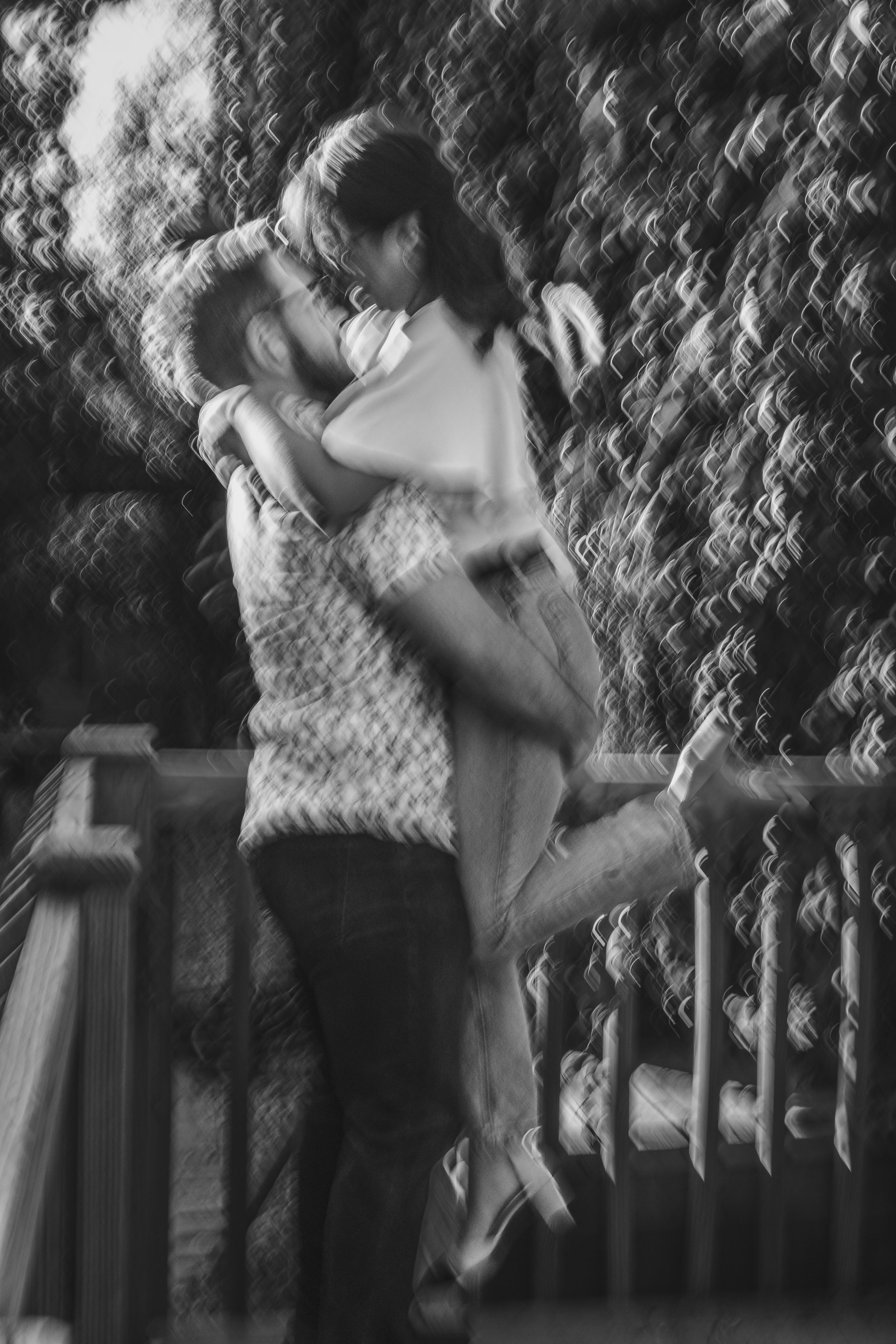 A romantic black and white image of two people embracing against a textured background.