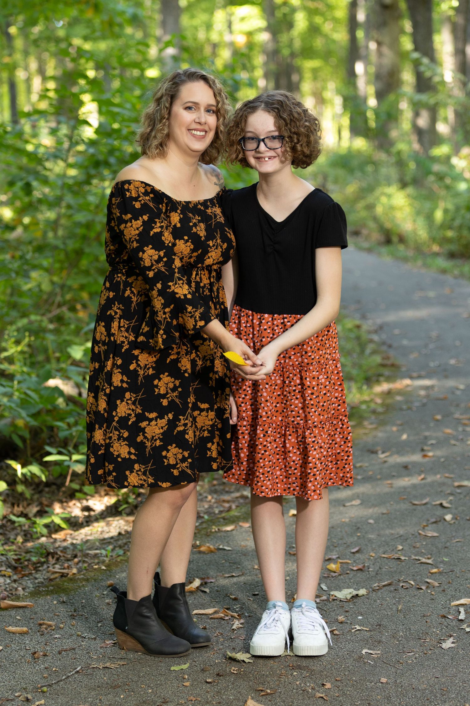 Mother and daughter stand together for a portrait.
