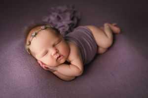 Red-headed newborn girl side-lying pose in purple. - Greenville SC newborn photographer - Easley SC newborn photographer