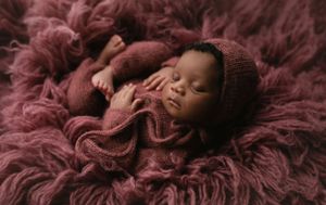 Beautiful black newborn baby on a furry rug wearing a mauve outfit. - Greenville SC newborn photographer - Easley SC newborn photographer