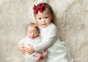 Older sister holding her newborn baby sister. - Greenville SC newborn photographer - Easley SC newborn photographer