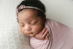Newborn black baby in a purple wrap showing her profile. - Greenville SC newborn photographer - Easley SC newborn photographer