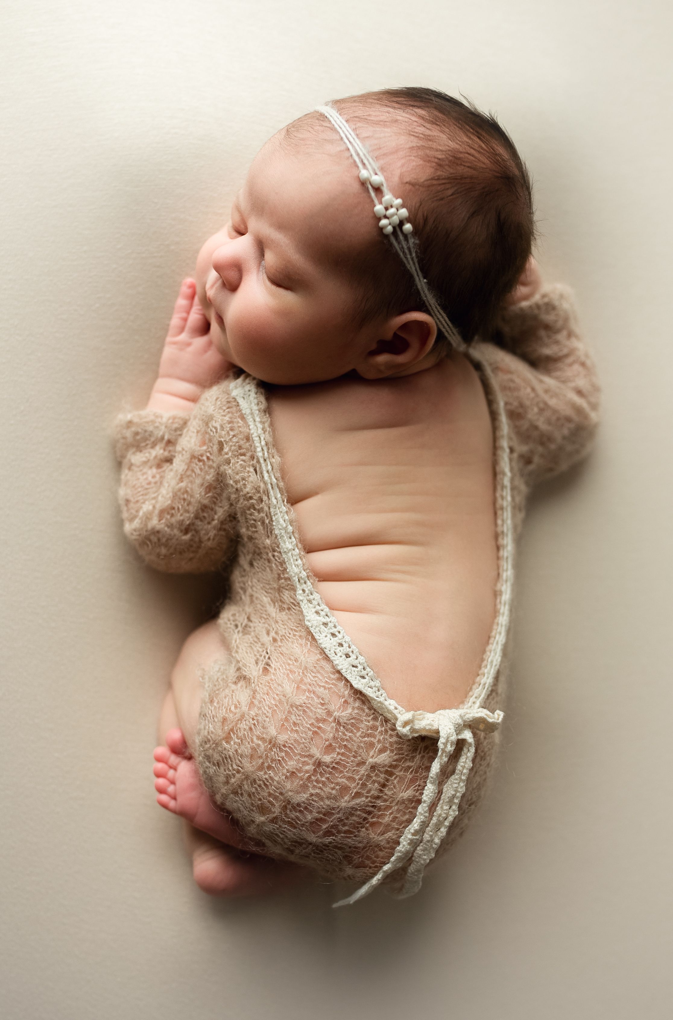 Tiny newborn baby girl in a tan lace outfit showing her back. - Greenville SC newborn photographer - Easley SC newborn photographer