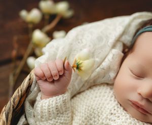 An up-close image of a newborn girl holding a flower. - Greenville, SC newborn photographer - Easley SC newborn photographer