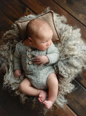 Newborn baby boy in neutral outfit on a fur rug. - Greenville SC newborn photographer - Easley SC newborn photographer