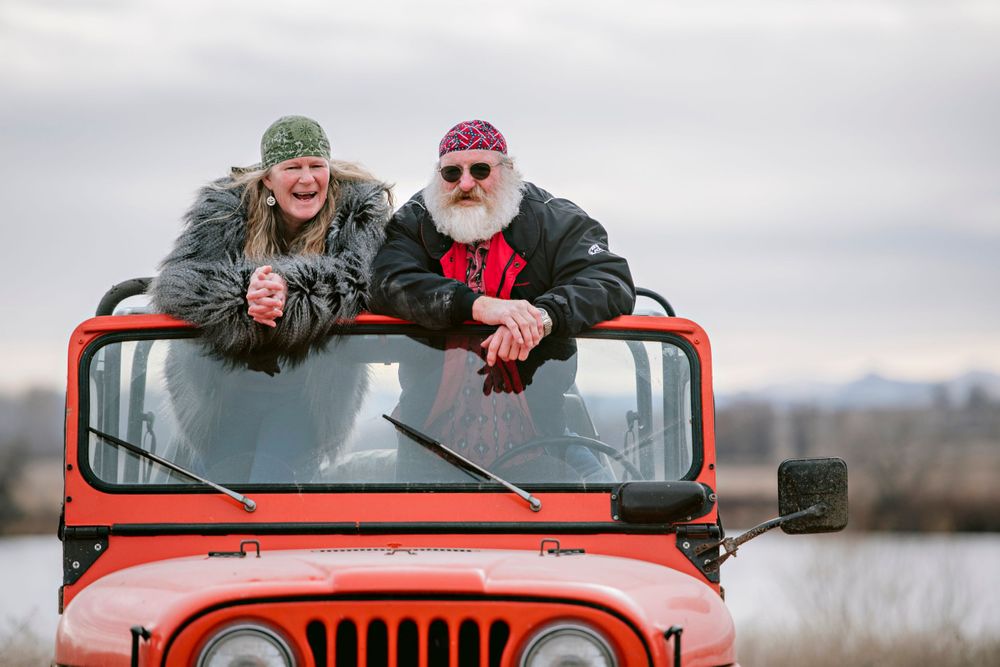 Laughing couple looks out of jeep