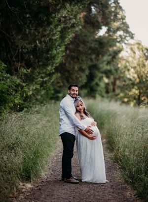 Intimate maternity portrait of couple embracing on nature trail.