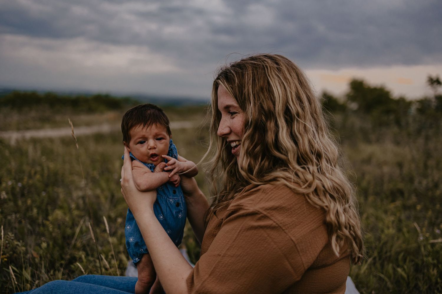 A moody outdoor family scene captured during sunset with dramatic clouds.
