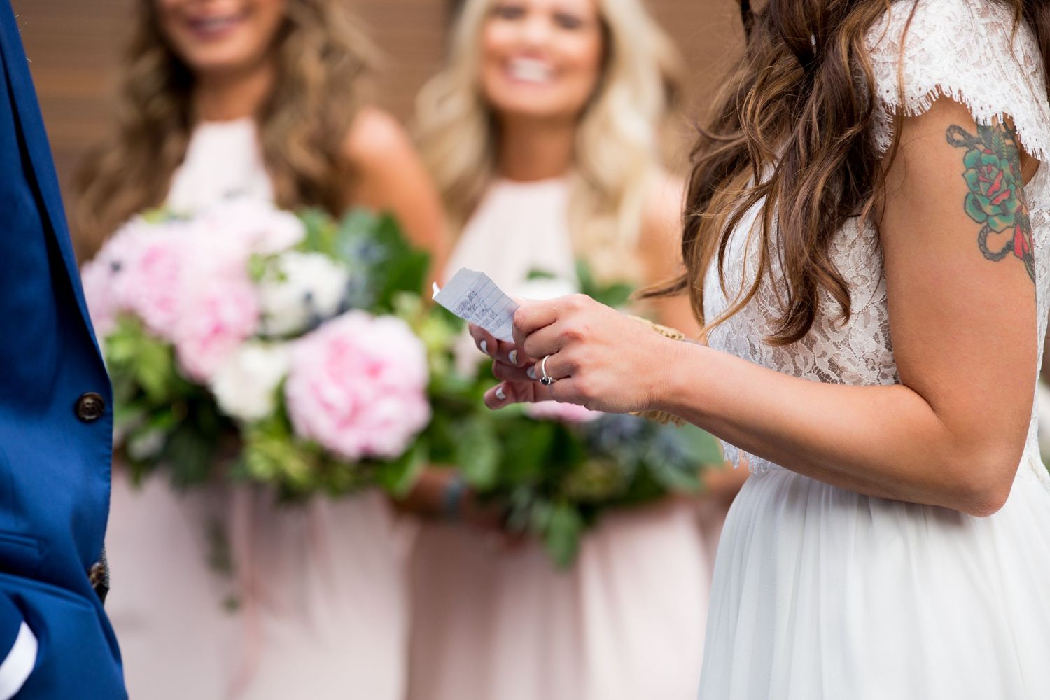 Close up of wedding party holding pink bouquets showing dress and floral details.
