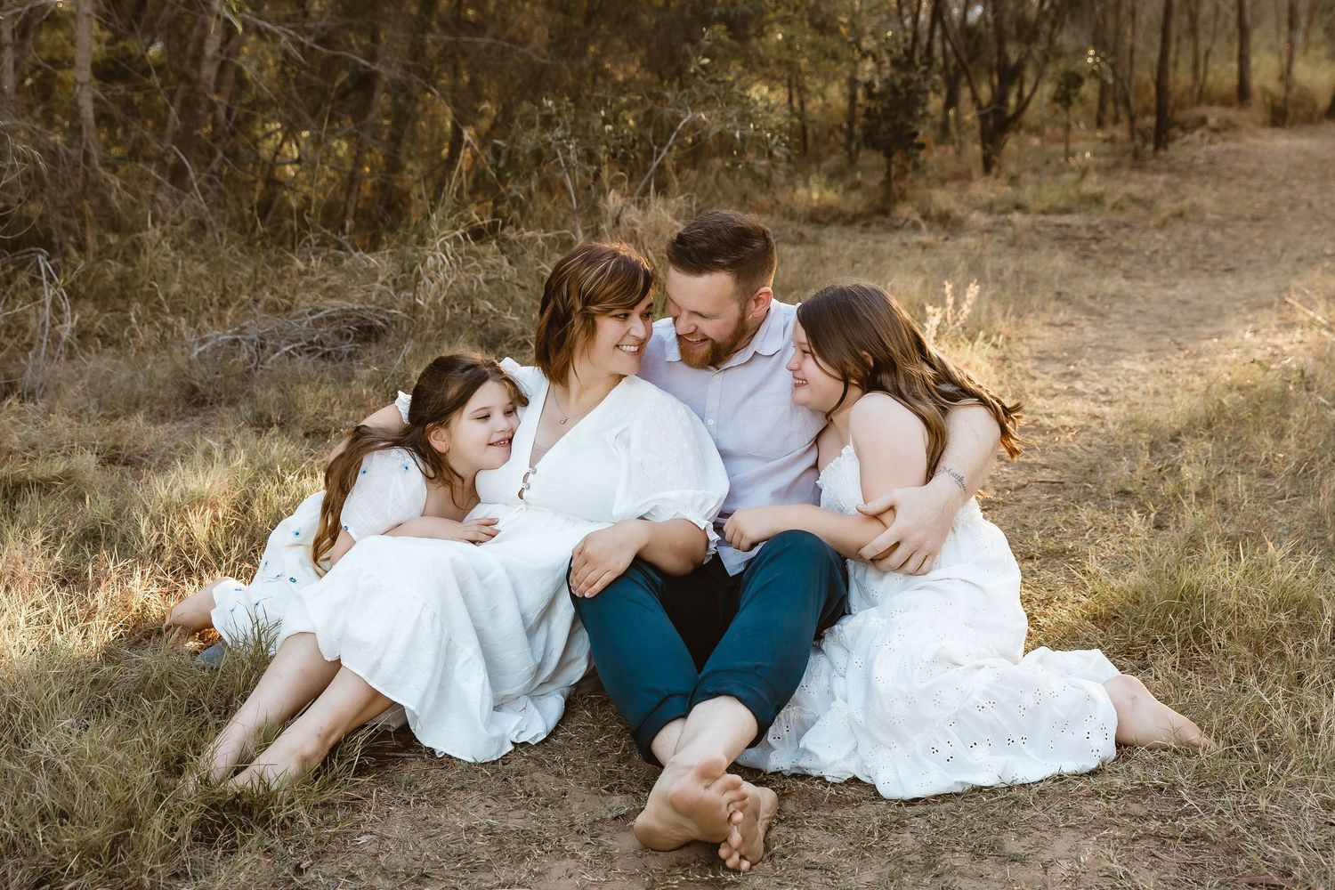 Seated family snuggles up together during a family photo session on Brisbane's northside