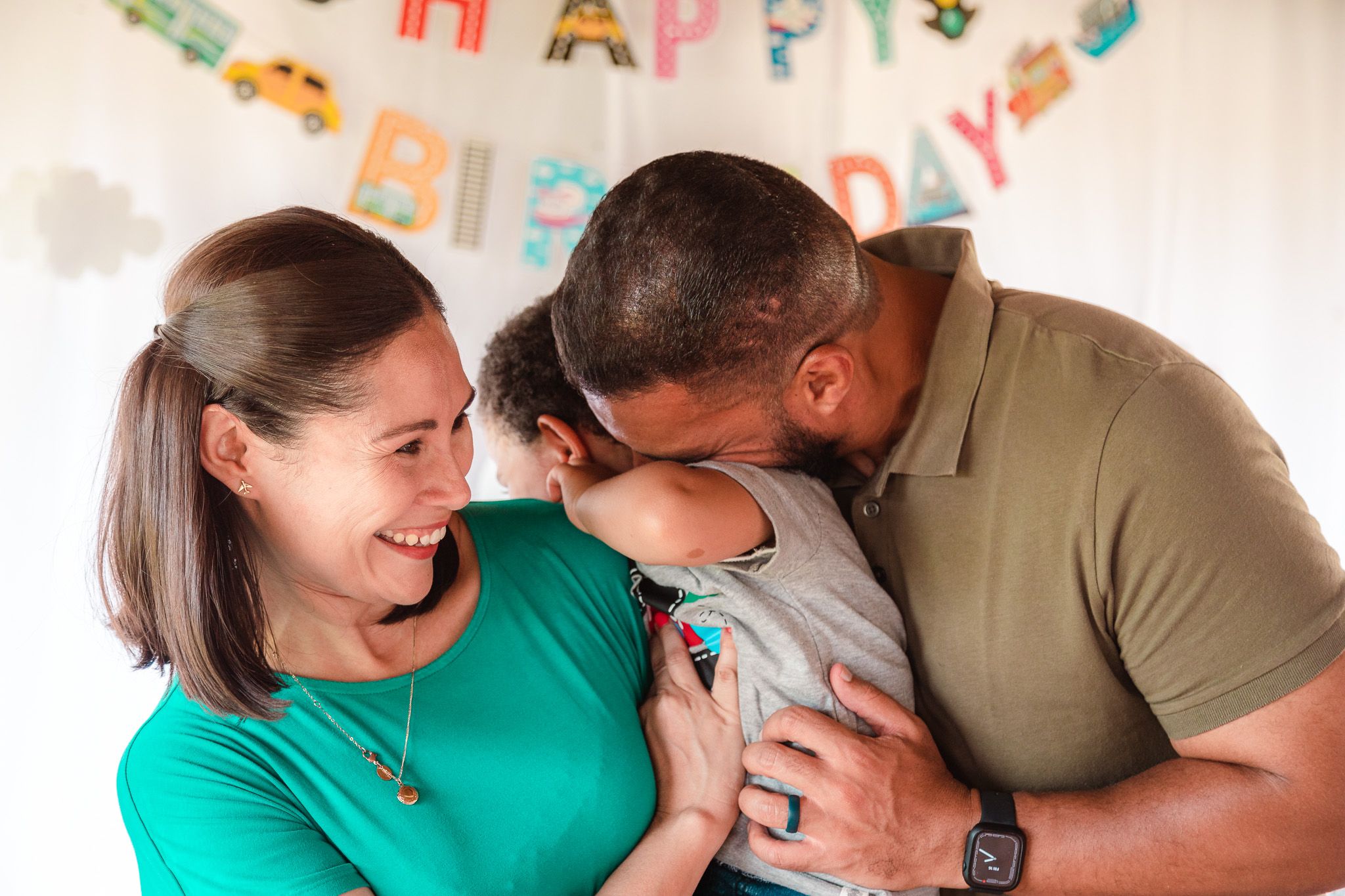 Intimate laughing moment with parents and a young son who is all coy