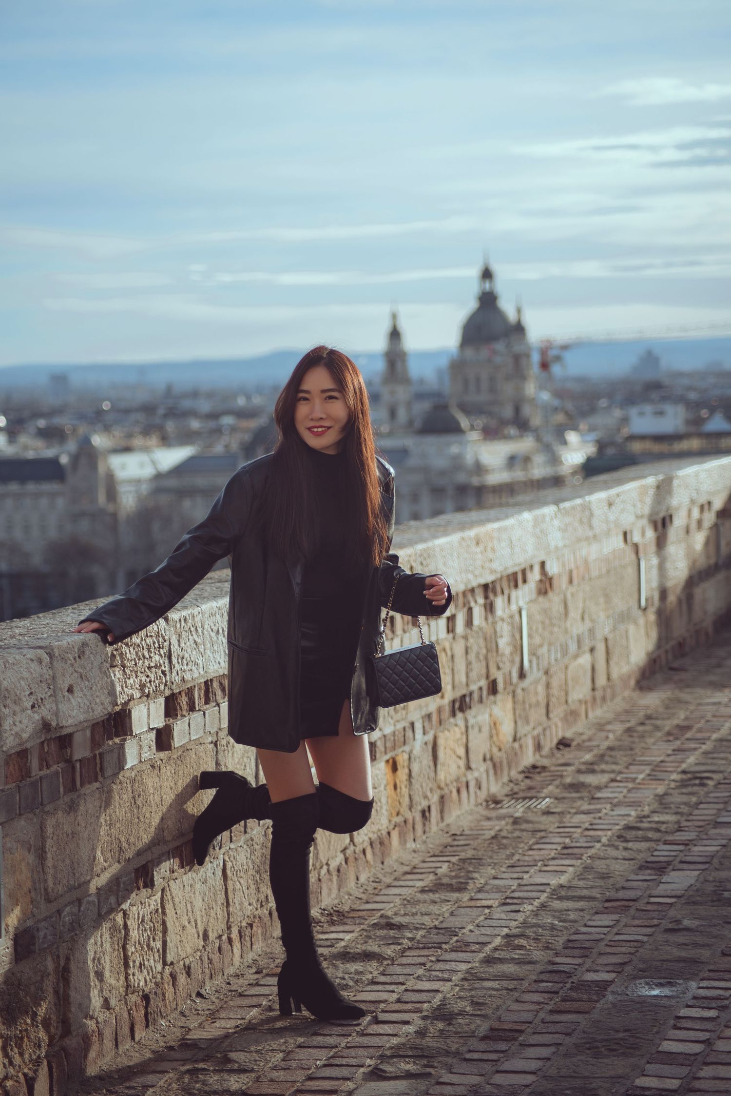 girl posing at buda castle for her photographer with the views of st. stephen's basilica as the backdrop