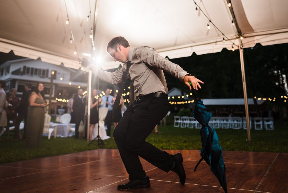 Wedding reception dance floor under tent with string lights creating festive atmosphere.