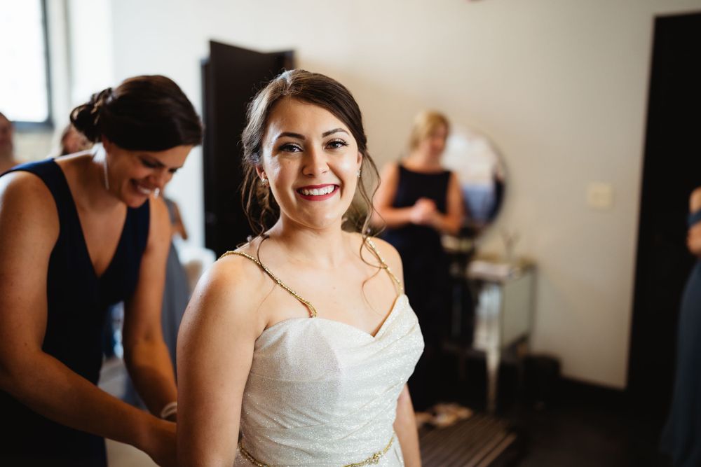 A wedding preparation scene in a bright room with joyful moments being captured.